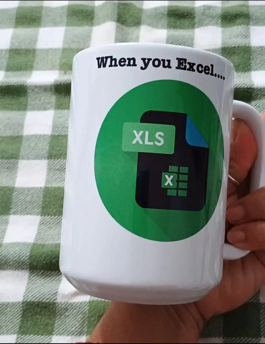White mug with Excel XLS file icon and text 'When you Excel...' on green checkered tablecloth