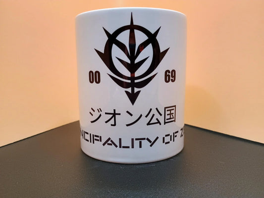 White ceramic mug with black Zeon emblem from Gundam and text in Japanese and English