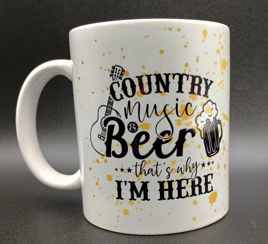 White coffee mug with yellow splatter featuring text 'Country music & Beer that's why I'm here' with guitar and beer mug graphics