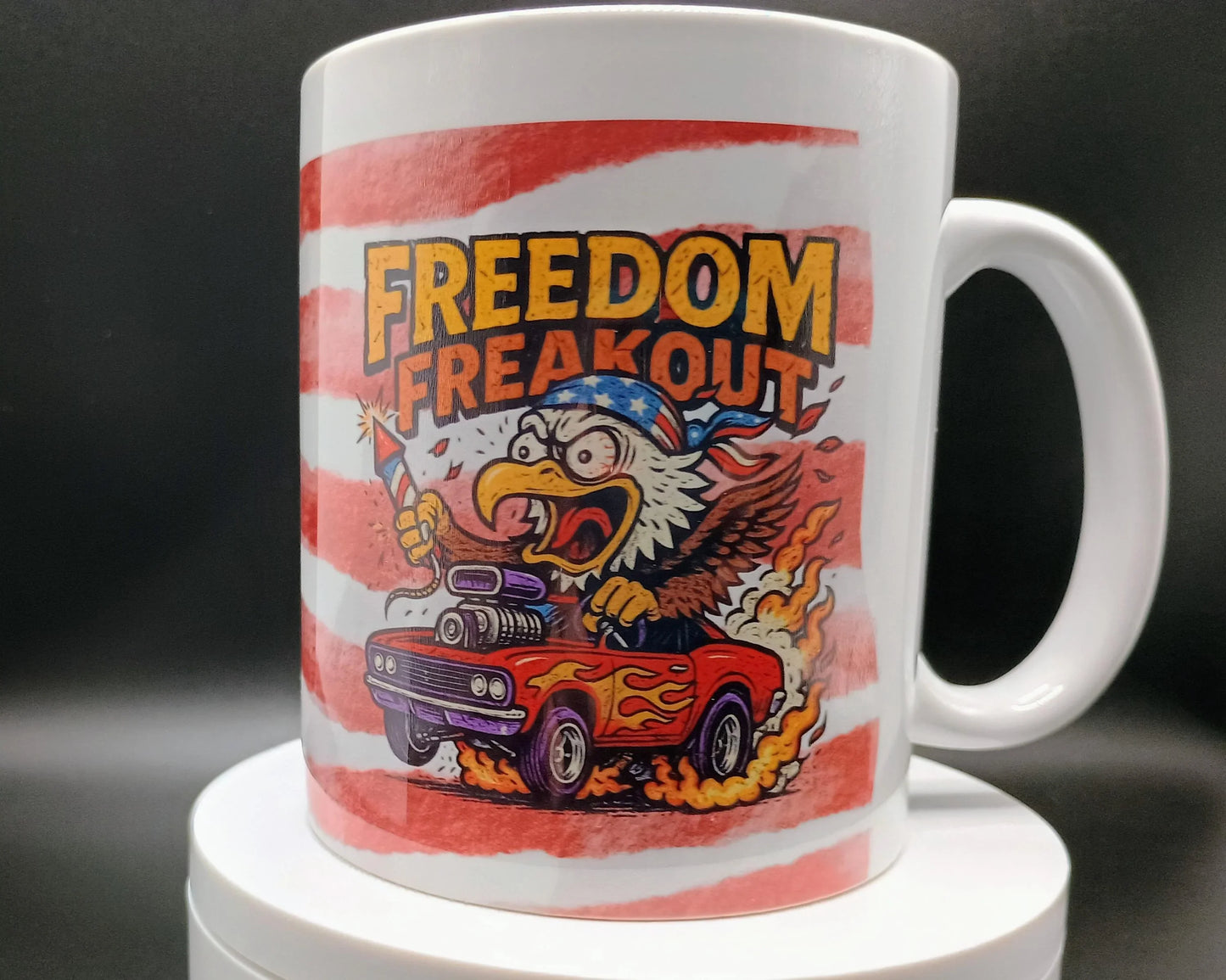 White mug with cartoon eagle in bandana driving flaming muscle car holding firework rocket and text Freedom Freakout