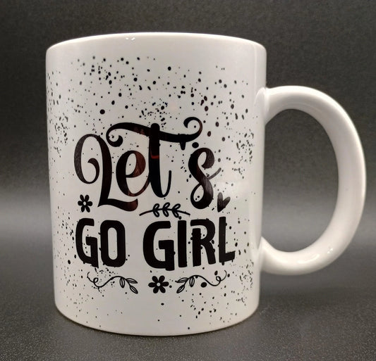 White ceramic mug with motivational text 'Let's Go Girl' and decorative black speckles