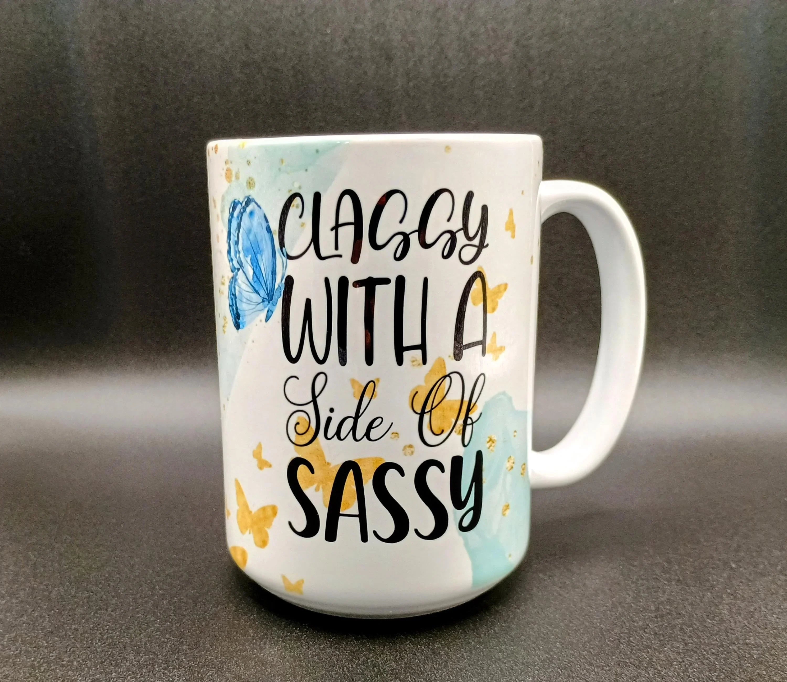 White ceramic mug with black text "Classy with a side of sassy" and blue and yellow butterfly designs