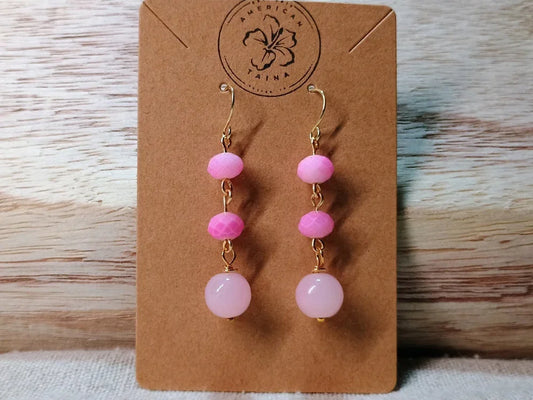 Pink beaded dangle earrings with gold hooks on brown card branded American Taina